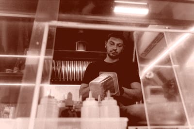 person drying dishes in a restaurant kitchen