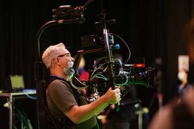 Camera operator using a gymbal to film in a studio
